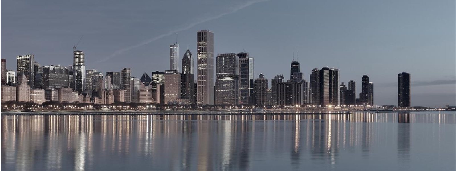 City skyline at dusk reflected in the water — ADNEC Phase 4, Capital Central